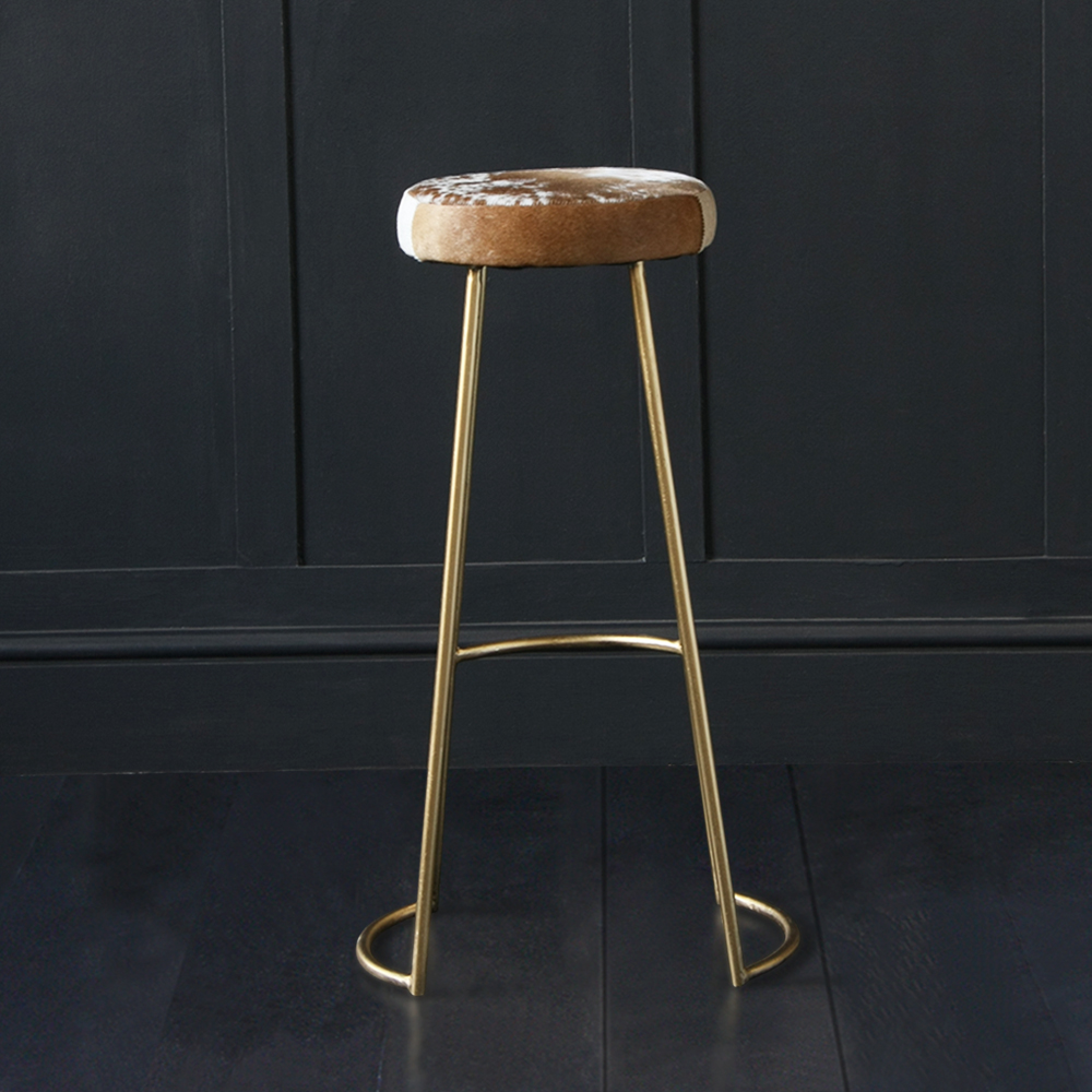 gold frame tapas bar stool with brown and white cowhide seat by Where Saints Go